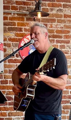 Dan Kenny playing acoustic guitar and singing songs